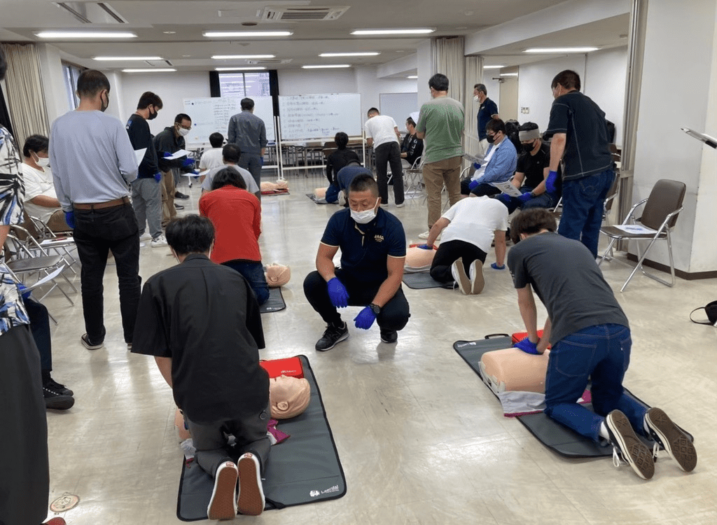 数名の男性が心肺蘇生法の練習している