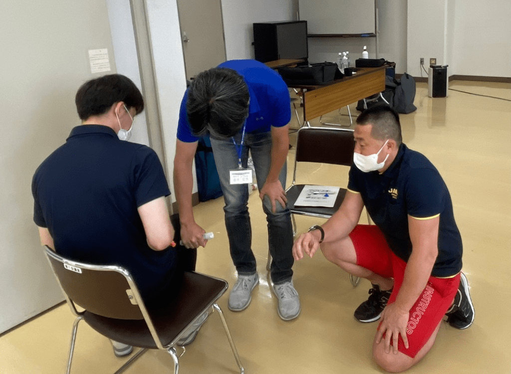 講師が見守る中エピペンを打つ練習